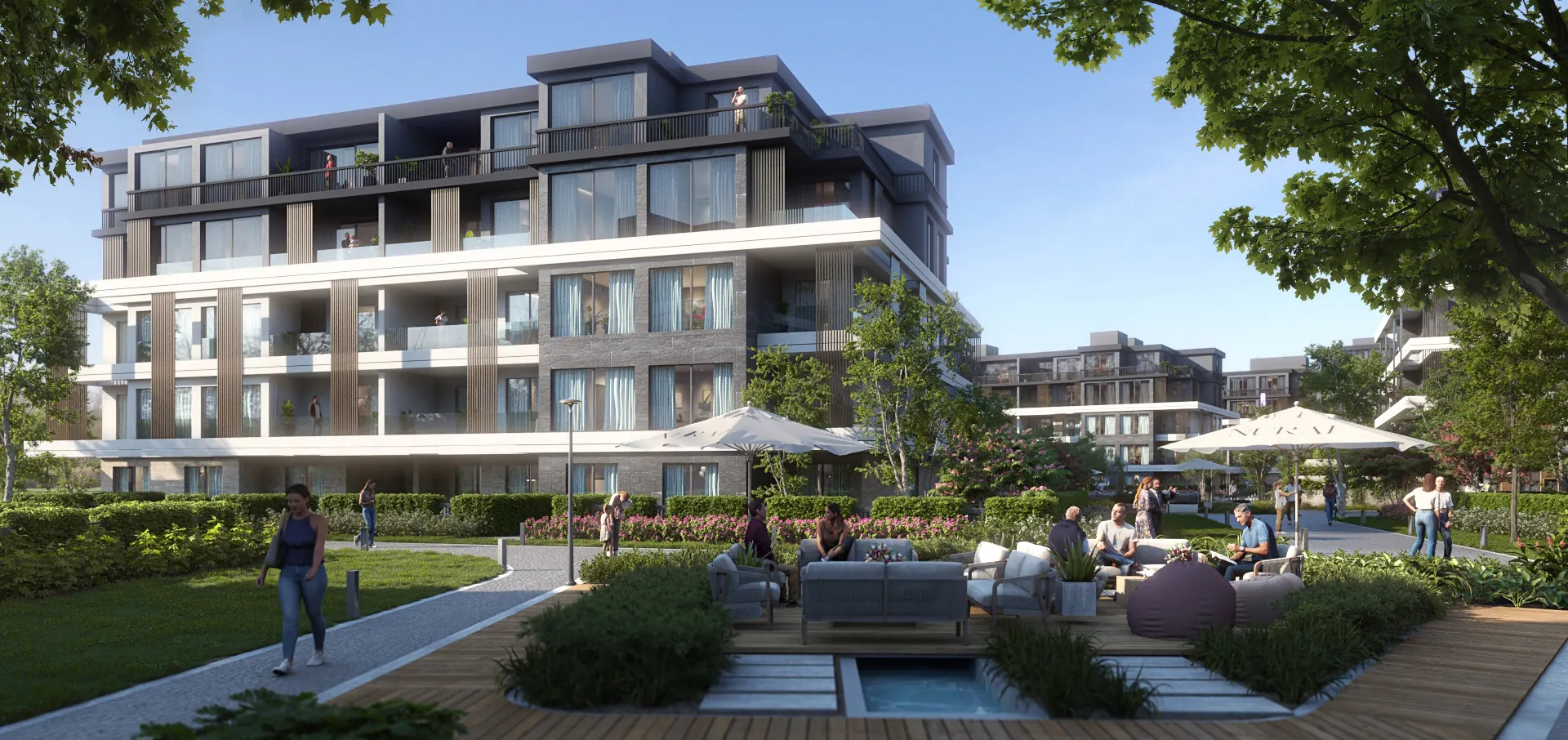 Outdoor lounge with sofas and umbrellas in a garden beside the residential buildings