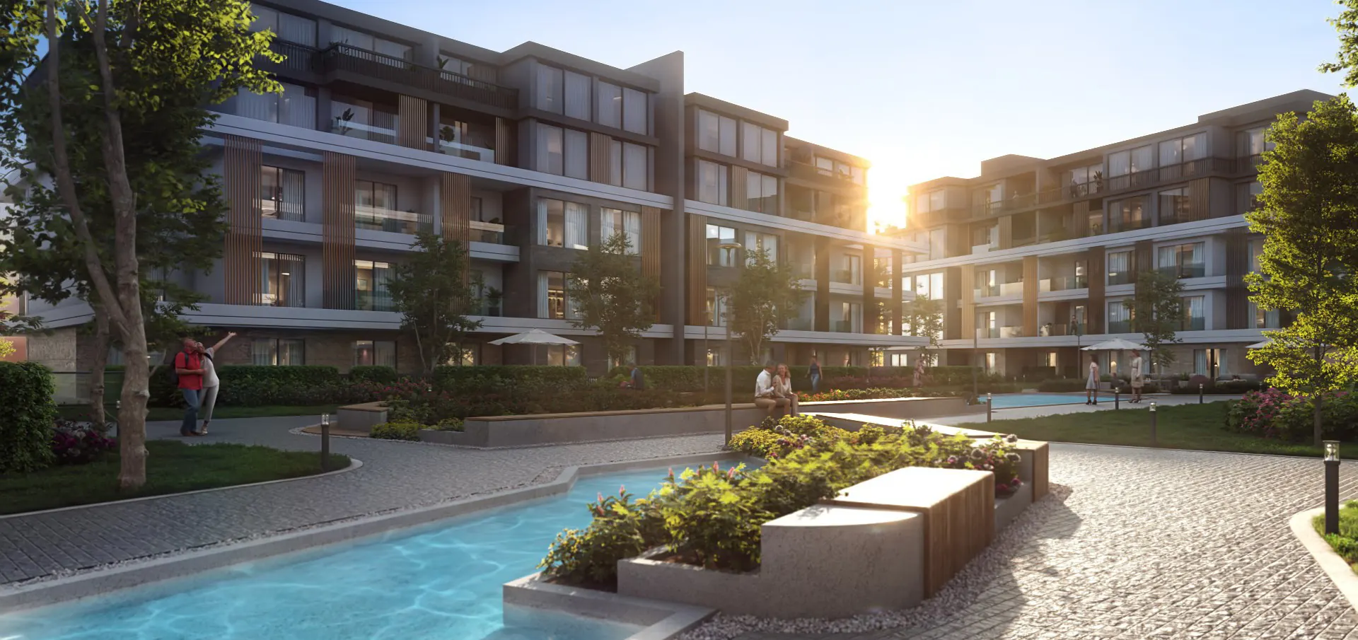 Water channel and a planted seating island at sunset among the U.Nurai buildings